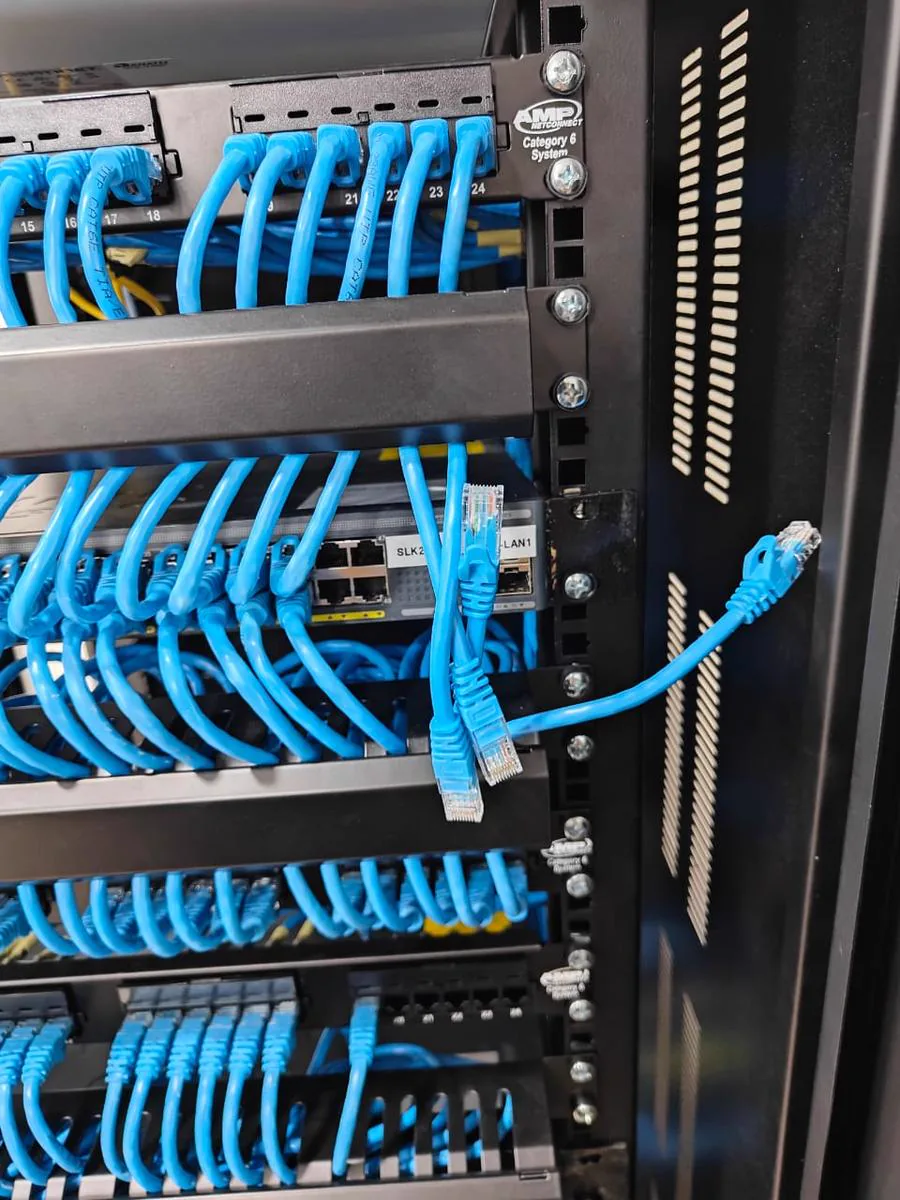 Close-up of TKWIT structured cabling terminated on patch panels inside a network rack in Sri Lanka